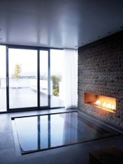 a large sunken bathtub with a faux stone wall and a fireplace in it is a gorgeous relaxing space