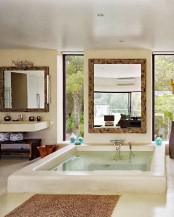 a stylish bathroom with a large sunken bathtub, with vertical windows for views and a large window that keeps your privacy