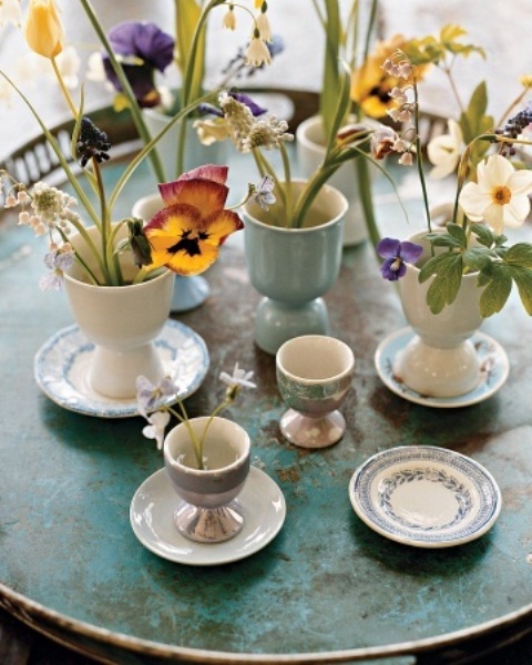egg cups and holders used as vases for colorful spring blooms and greenery for Easter decor