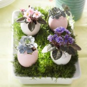 a tray with grass, pastel eggs with succulents and bright blooms is a gorgeous Easter centerpiece