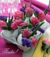 a carton with eggs and purple and pink blooms is an easy Easter centerpiece idea