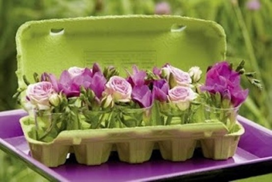 a green carton with purple and bloom arrangements is a cool Easter decoration
