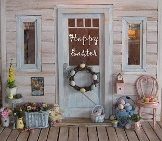 a pastel spring porch with a colorful egg wreath and basket, a basket with blooms and potted blooms