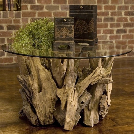a large table made of driftwood and a round glass tabletop can be used as a lovely console or coffee table, both indoors and outdoors