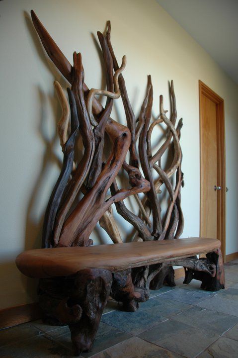 an entryway decorated with dark stained driftwood and a matching bench with legs made of driftwood, too, is a unique idea for a bold natural statement