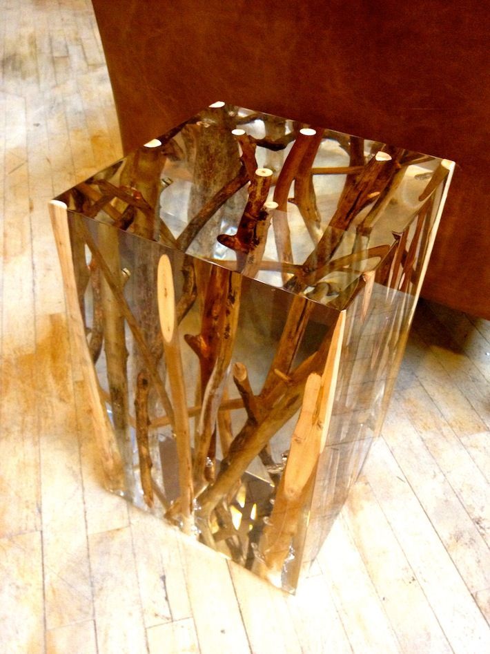 a beautiful and edgy small side table with driftwood and branches inside that are seen through the sheer cube very well is a lovely way to add a natural feel to your space