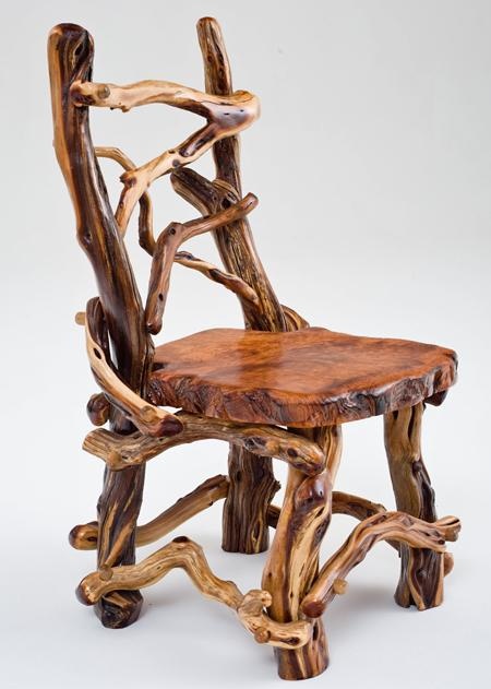 a creative chair made of wood slices and driftwood and stained dark looks creative and pretty and gives a rustic feel to the space