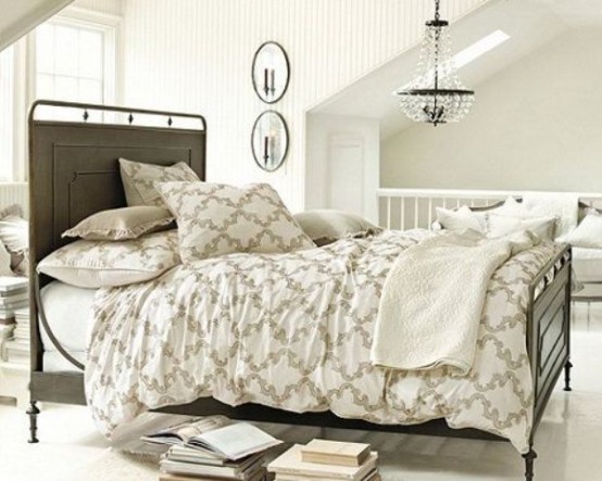 a stylish neutral bedroom with a vintage feel, with striped wallpaper, a crystal chandelier and a metal bed with printed bedding