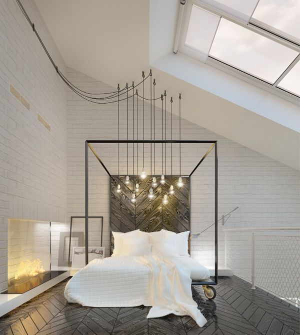 a black and white attic bedroom with a skylight, a fireplace with lights, a metal bed on casters with white bedding and a cluster of bulbs