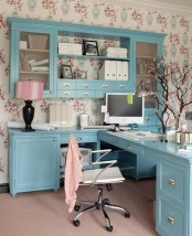 a cute feminine home office with floral wallpaper, blue furniture, table lamps and blooming branch decor