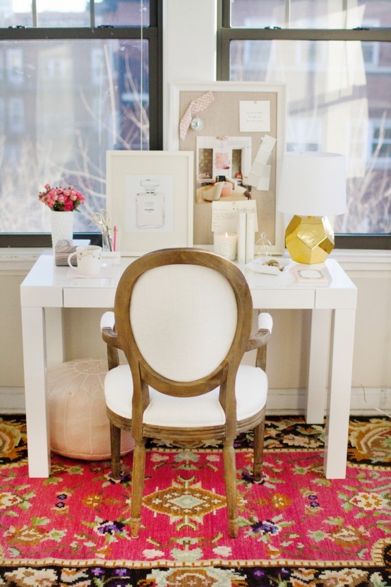 a bright feminine home office with neutral walls, a white desk and a chair, a bright printed rug and touches of gold