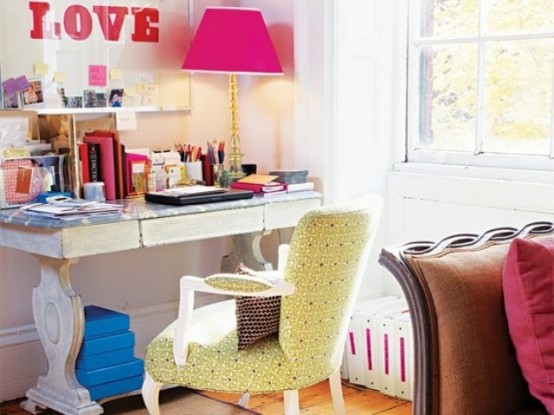 a vibrant feminine home office with an exquisite desk, a green chair, a pink lamp and decorations