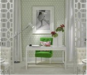 a stylish green and white girlish home office with printed wallpaper,  white furniture, a green art and cool art