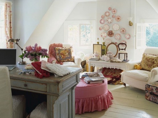 an attic shabby chic and vintage home office with a shabby desk, refined chairs, a pink decorative plate arrangement and a pink ottoman