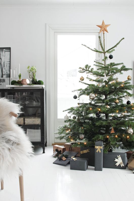 a Christmas tree with black, silver and gold ornaments and gold star topper and lights is modern and chic elegance