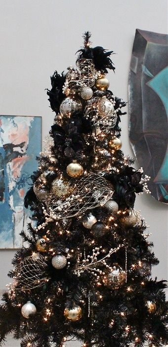 a black Christmas tree with lights, glam metallic ornaments, black feathers and metallic nets is a lovely and chic idea