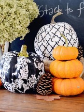refined stenciled black and white pumpkins paired with natural orange ones are all you need to decorate your space for Thanksgiving