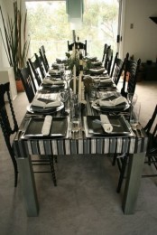 a chic black and white Thanksgiving tablescape with dark pumpkins and some greenery to refresh it is very cool and bold