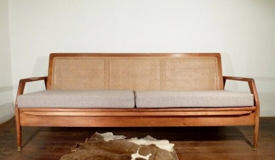 a chic mid-century modern sofa with stained frame and armrests plus a rattan back and an upholstered seat