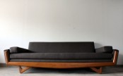 a black mid-century modern sofa with a stained frame is a stylish and practical solution for many spaces