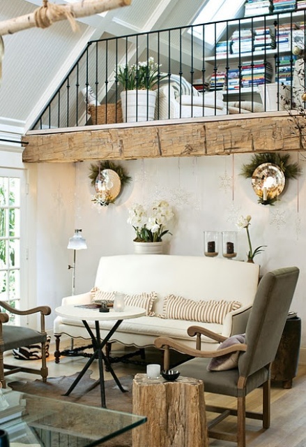 a French famrhouse living room with white and grey furniture, wood touches, potted blooms and greenery