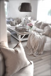 a neutral and whitewashed shabby chic living room with simple and elegant furniture, a low table and pendant lamps