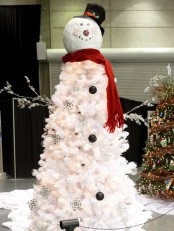 a white snowman Christmas tree with lights and some black ornaments plus a snowman head and arms
