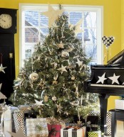 a traditional Christmas tree with large silver ball ornaments and stars, snowflakes and lights plus garlands
