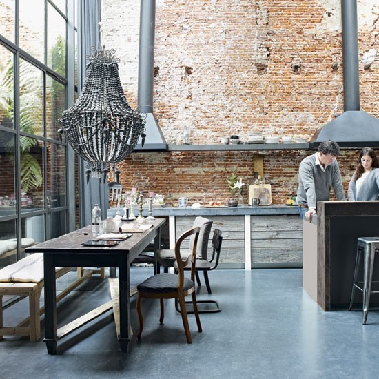 Weathered wood cabinets looks great and unified with the tall exposed brick wall on this gorgeous industrial-style kitchen.