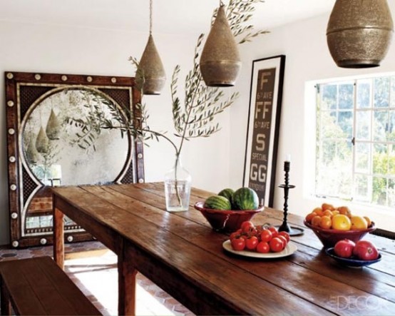 a rustic dining space made more boho with Moroccan touches - metal pendant lamps and a large mirror in a carved wooden frame
