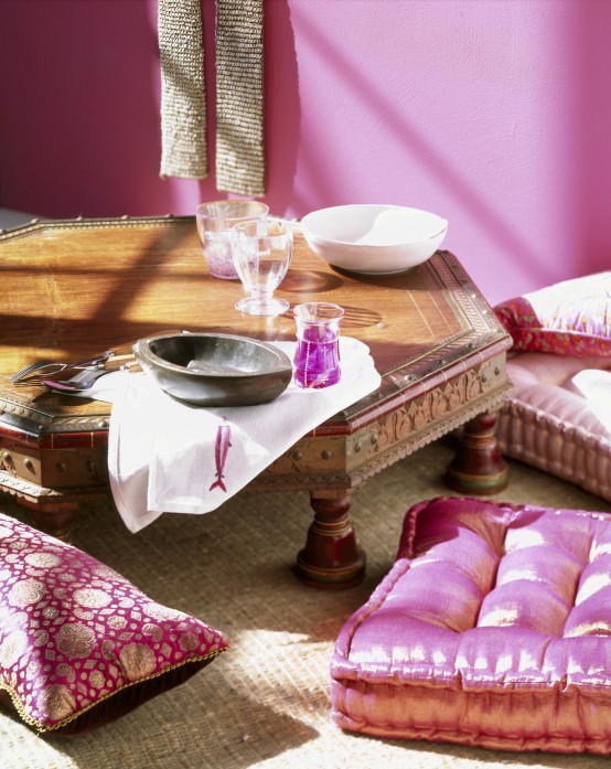 a pink Moroccan dining space wiht a low hexagon table, pink and fuchsia printed pillows looks boho chic and welcoming