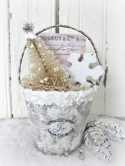 a shiny silver glitter bucket with hay, a white bottle brush tree and a large clay snowflake is an amazing decoration for Christmas