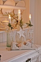 clear bottles as candleholders decorated with evergreens and clay tags are amazing for styling your space for Christmas