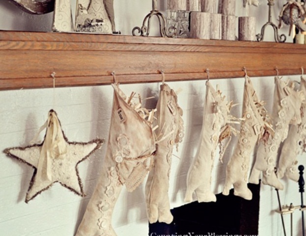 neutral Christmas stockings decorated with buttons and matching stars hanging make the mantel feel holiday like and very chic