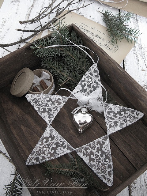 a tray with a white lace star with a bell and some evergreens for dreamy and chic Christmas decor
