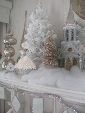 a refined vintage snowy Christmas mantel with faux snow, silver glitter houses, mercury glass ornaments is a beautiful and out fo the box idea