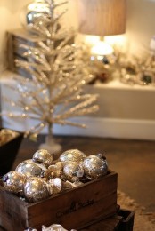 a stained crate with silver ornaments and a silver Christmas tree will make the look of your space chic and bold