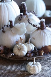 a woven bowl with fall leaves, faux pumpkins and white fabric pumpkins can become a great fall centerpiece or decoration