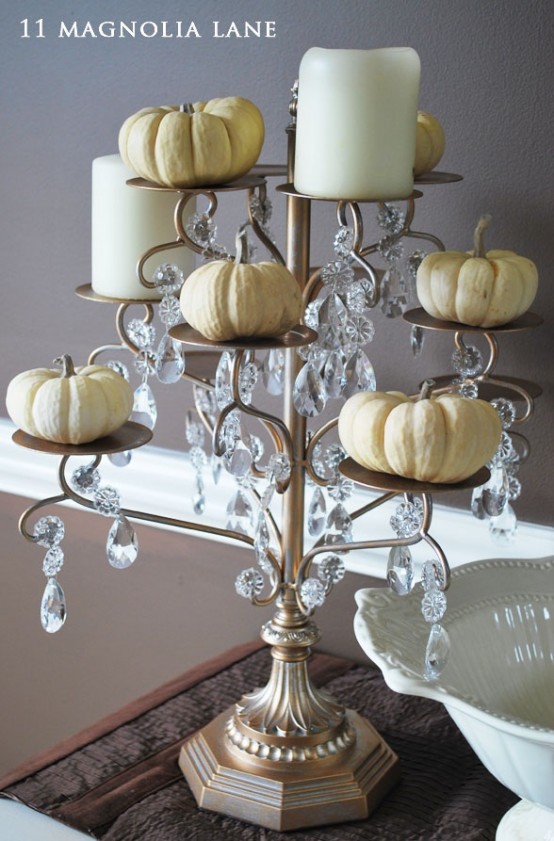 a refined metal stand with crystals, white pillar candles and pumpkins is a very cool idea to go for