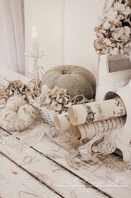 neutral shabby chic fall decor with white lace, dried leaves, vintage prints, neutral and painted pumpkins and candles