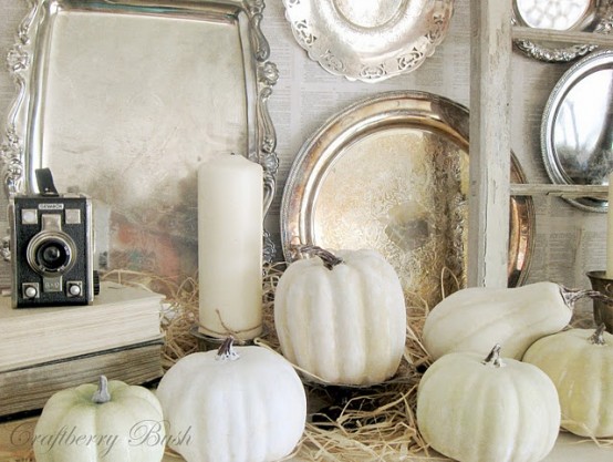 white hay, pillar candles, gourds and pumpkins make up a very exquisite and chic arrangement in the space