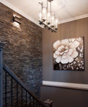 a dark textural wall of faux stone adds interest to the space and makes it chic and catchy