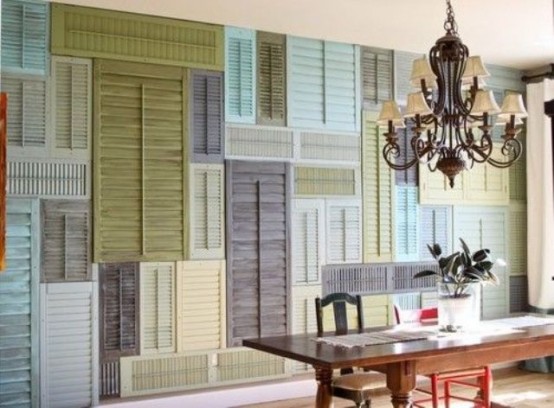 an accent wall all clad with colorful vintage shutters is a very bold and chic solution for the space