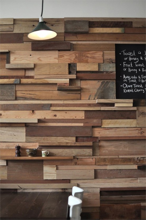 a unique accent wall done with lots of wooden slabs and planks in various colors adds a rustic and industrial touch