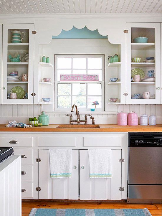 a vintage kitchen in white, with a beadboard backsplash, butcherblock countertops, touches of blue, mint green and pink is lovely