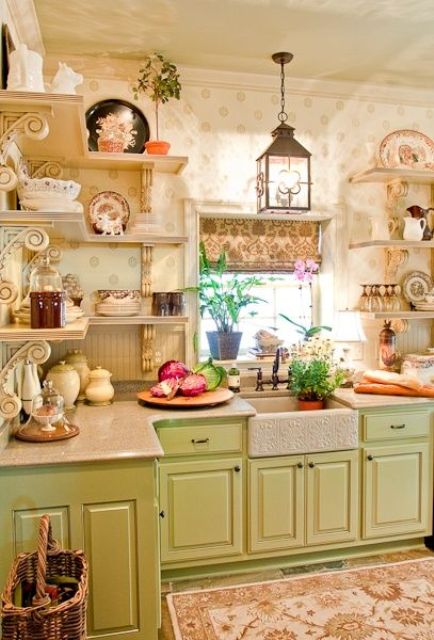 a vintage kitchen with green cabinets, open shelves, floral print wallpaper, vintage decor, pendant candle lanterns and printed rugs