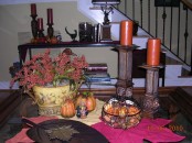 rust candles, fake pumpkins, a bold floral arrangement and leaf bowls for traditional fall coffee table decor