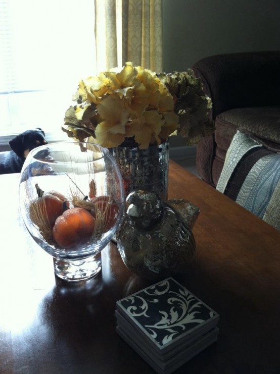 an aquarium with wheat and fall pumpkins plus a bright dried floral arrangement for coffee table decor