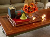 a tray with pinecones and a bright floral arrangement is all that you need for fall coffee table styling