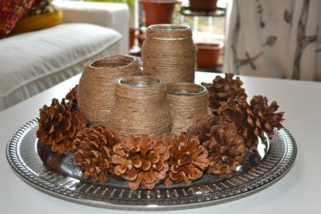 a tray with pinecones and twine wrapped vases or candleholders is a cool and simple rustic decoration